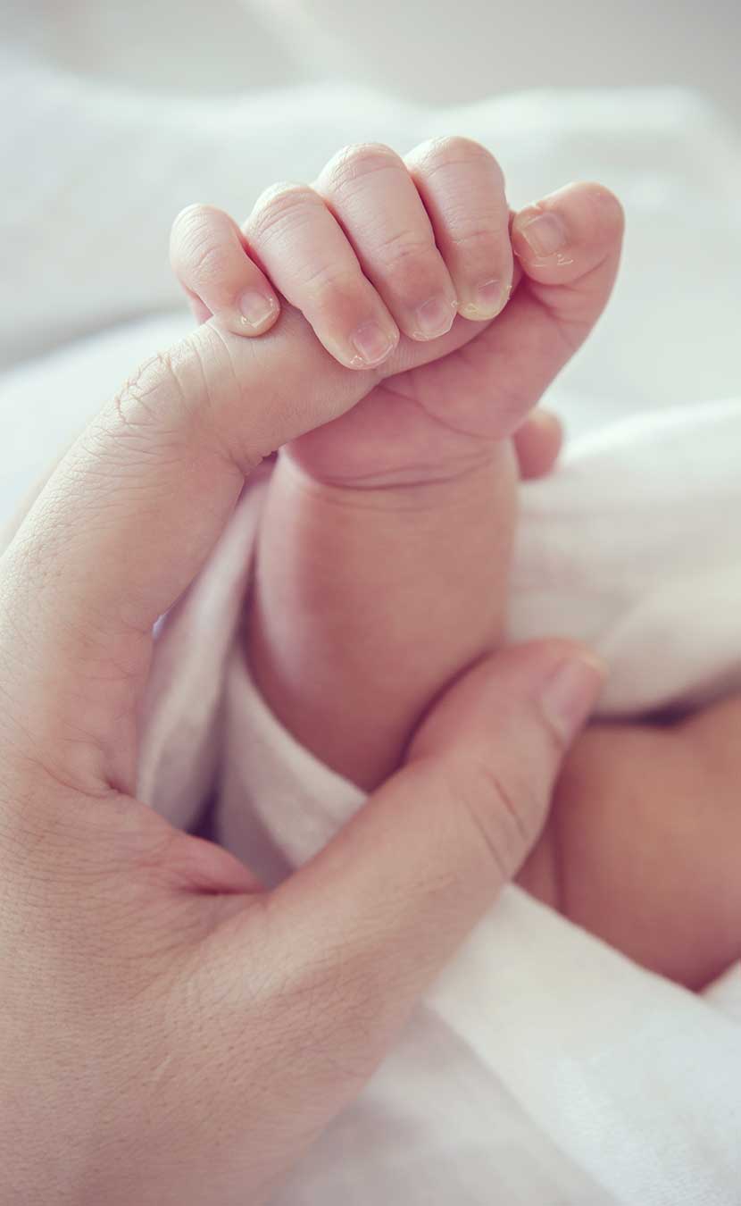 Baby holding Mother's finger